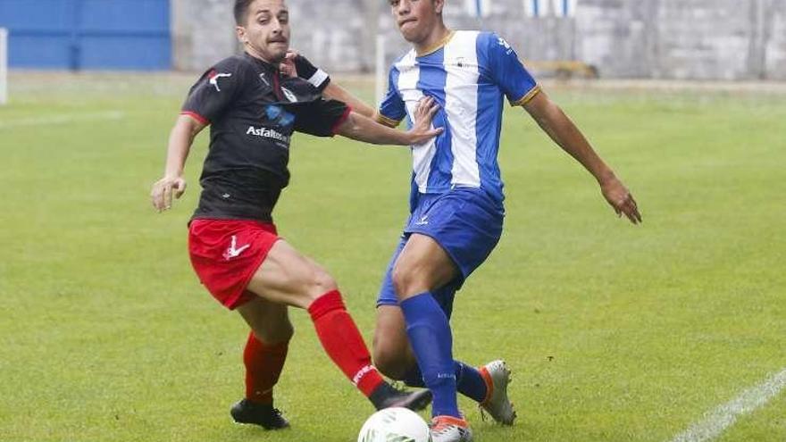 Jairo disputa un balón con Keko (Avilés) en el Suárez Puerta.