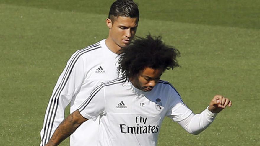 Marcelo toca el balón por delante de Cristiano Ronaldo.