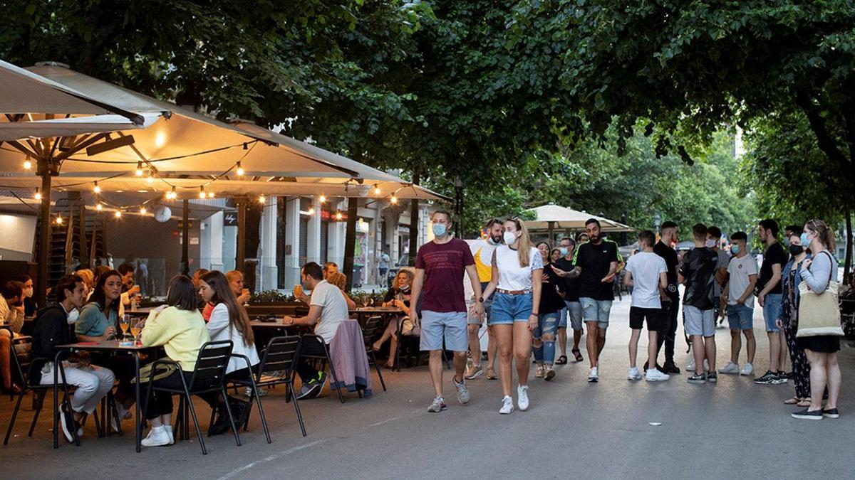 Varias personas guardan cola en una terraza de Rambla Catalunya en este primer día de la fase uno de la desescalada en que el las terrazas de los bares y restaurantes pueden abrir al 50 de su capacidad