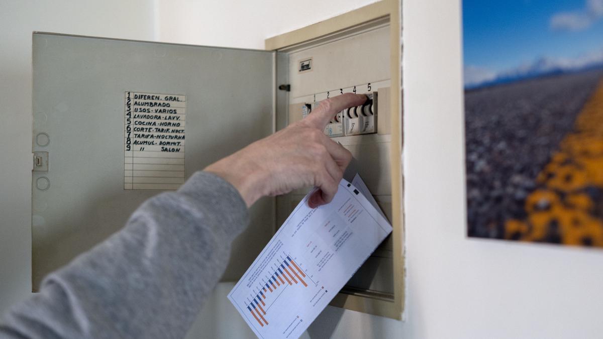 Archivo - Un hombre sube los plomos de la luz con una factura de luz en la mano, a 3 de enero de 2022, en Madrid, (España).