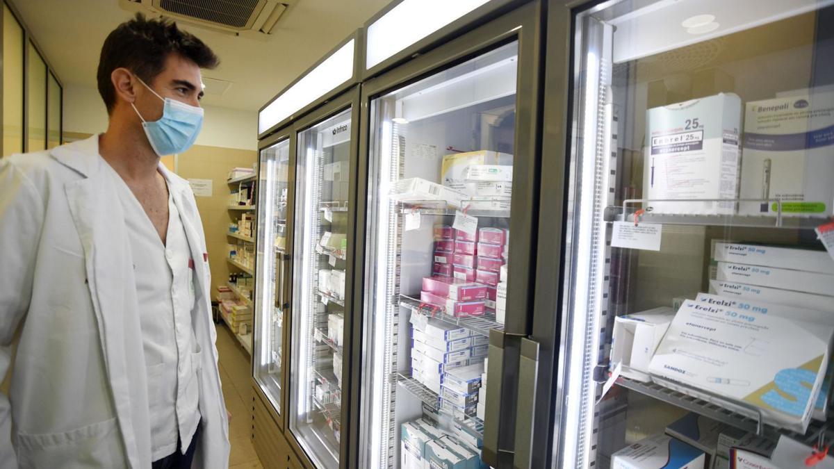 Un especialista del servicio de Farmacia, frente a un estante con medicinas comunes del hospital