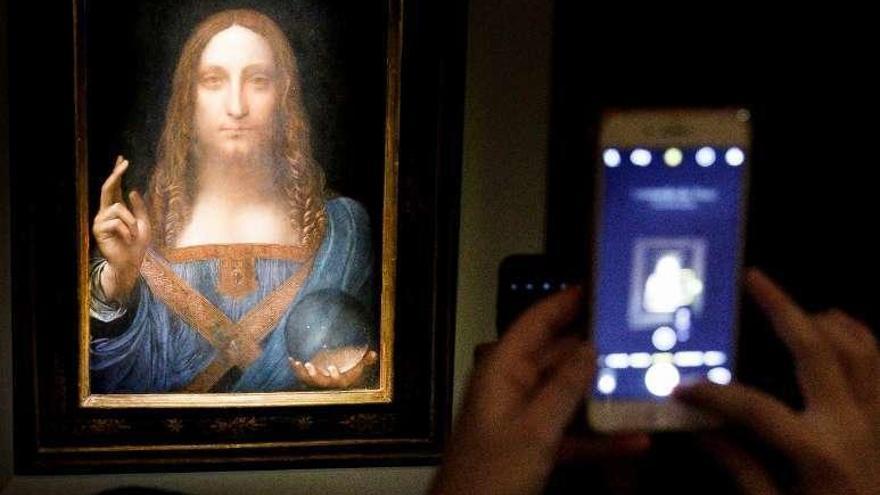 Una persona toma una foto del &quot;Salvator Mundi&quot; de Leonardo. // J. Lane