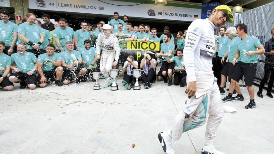 Hamilton bromea antes de posar junto a Rosberg con los demás componentes de Mercedes. // P. Whitaker