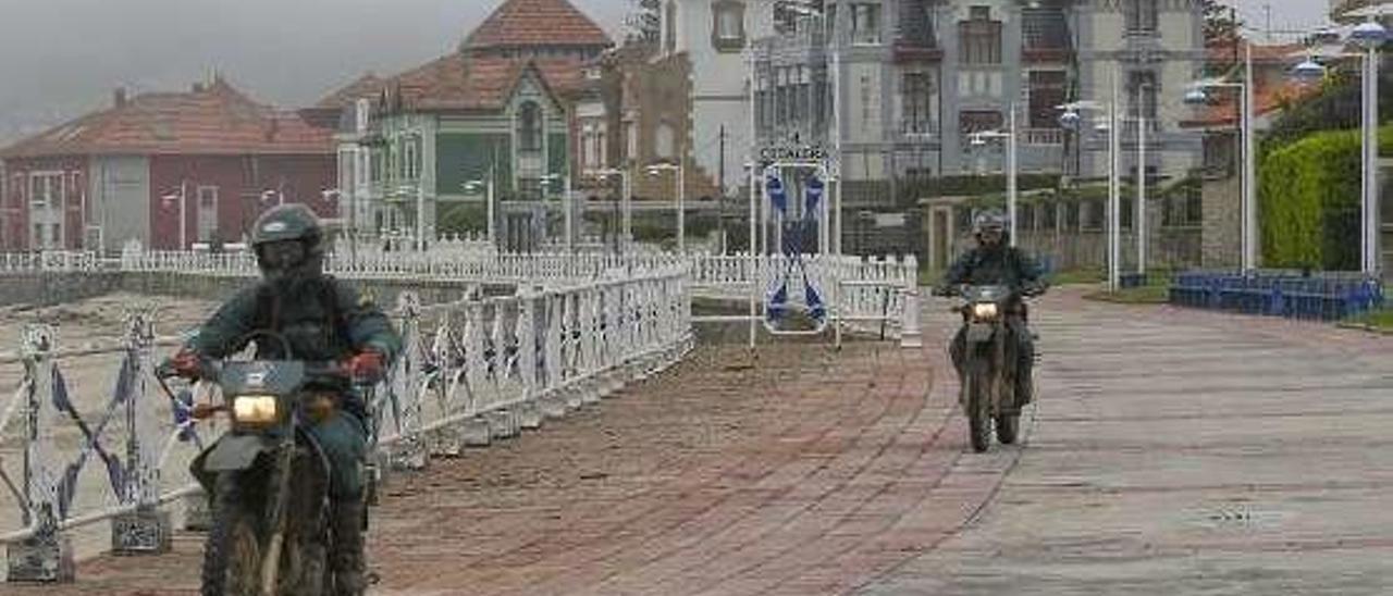 Dos guardias civiles en moto, por el paseo de la playa, a mediodía de ayer.