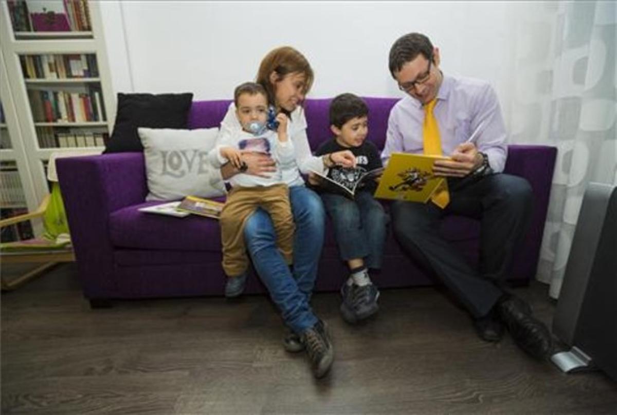 Gabriela Navarro i Jordi Martínez practiquen la lectura amb l’Arnau (sis anys) i el Pau (dos anys).