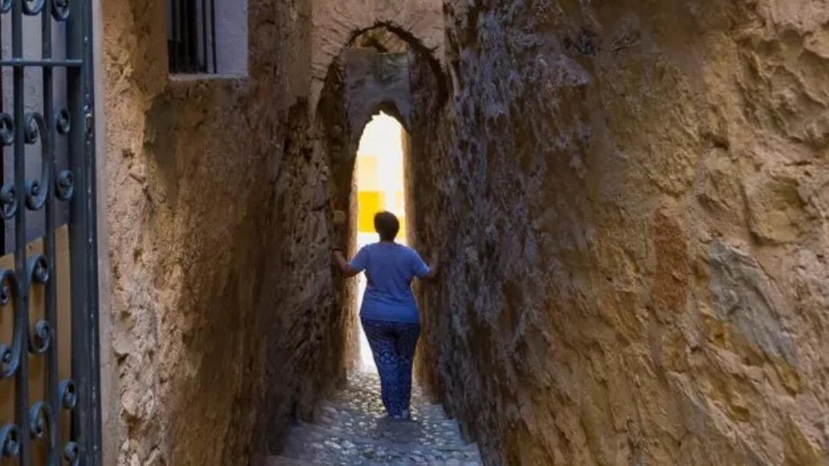 Una persona muestra la calle más estrecha de Catalunya.