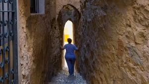 Una persona muestra la calle más estrecha de Catalunya.