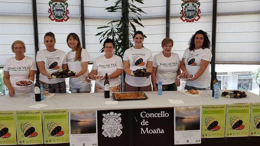 Representantes del Concello y de la Asociación de Mulleres con raciones de producto. // G. Núñez