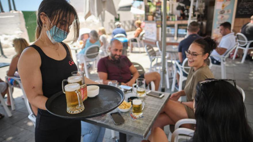 Una camarera sirve una mesa de una terraza tras la reapertura.