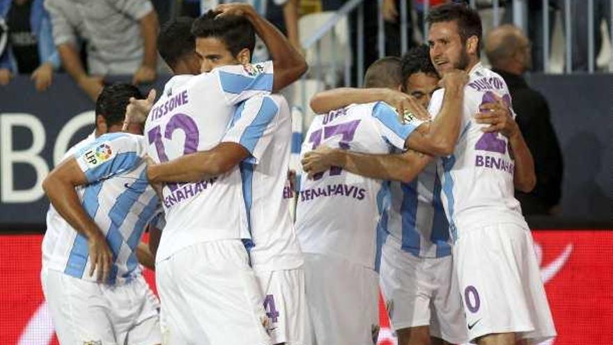 Los jugadores del Málaga celebran uno de los goles logrados por Charles que le dieron el triunfo.