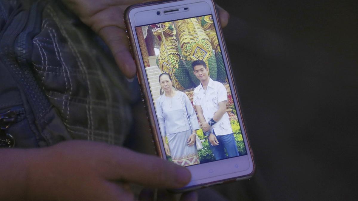 La tia del entrenador Ekapol Chantawong muestra una foto de móvil en la que aparece él y su abuela