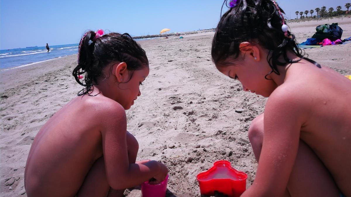 Dos niñas juegan en una playa.