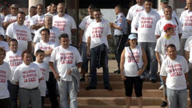 Un grupo de cazadores, ayer, durante la celebración del pleno, luciendo una camiseta contra la medida.