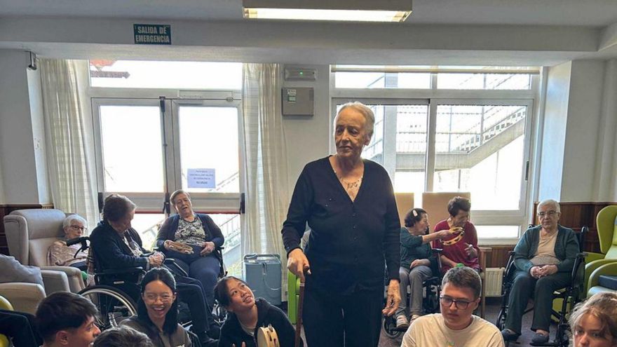 Usuaria de As Dores, ayer, rodeada de los alumnos maristas.