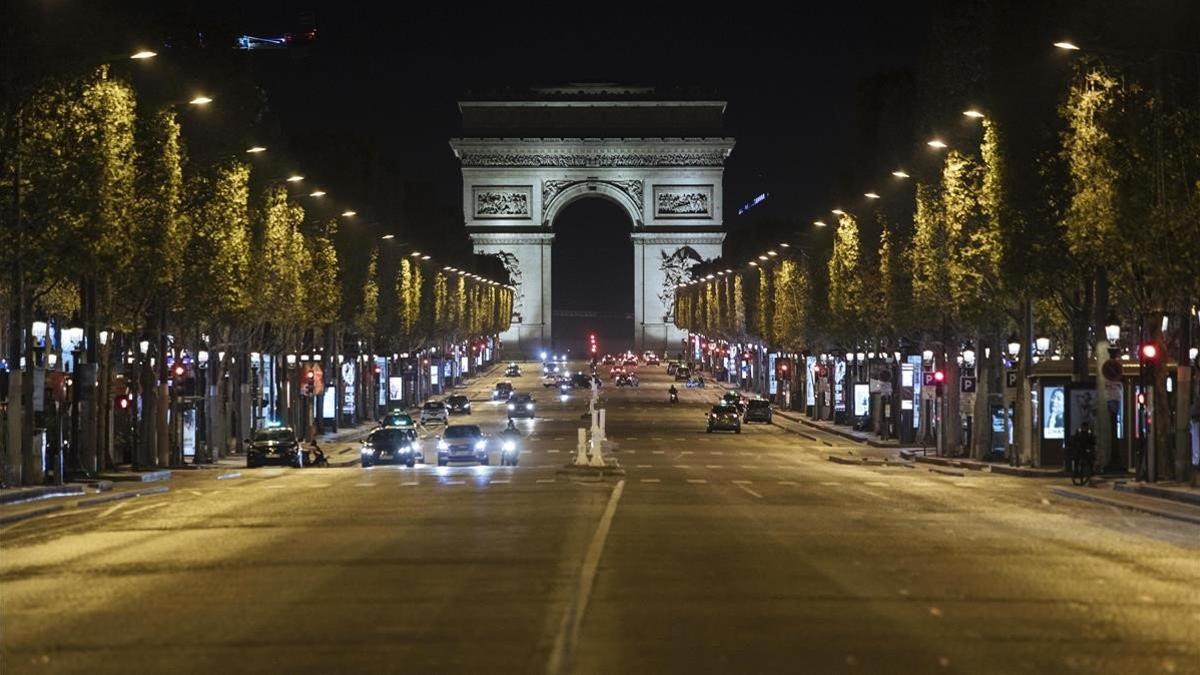 La avenida de los Campos Elíseos, con el Arco de Triunfo al fondo, casi vacía durante el toque de queda en París.