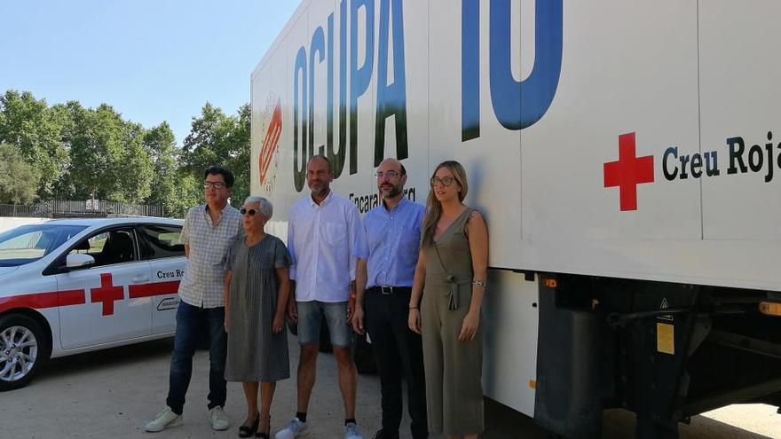 Responsables de la Creu Roja i de Mascotrans Logístics davant el vehicle donat, a La Copa