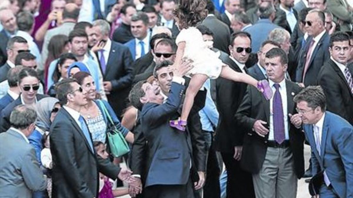 El primer ministro turco, Ahmet Davutoglu, celebra la liberación levantando a la hija del cónsul en Mosul.