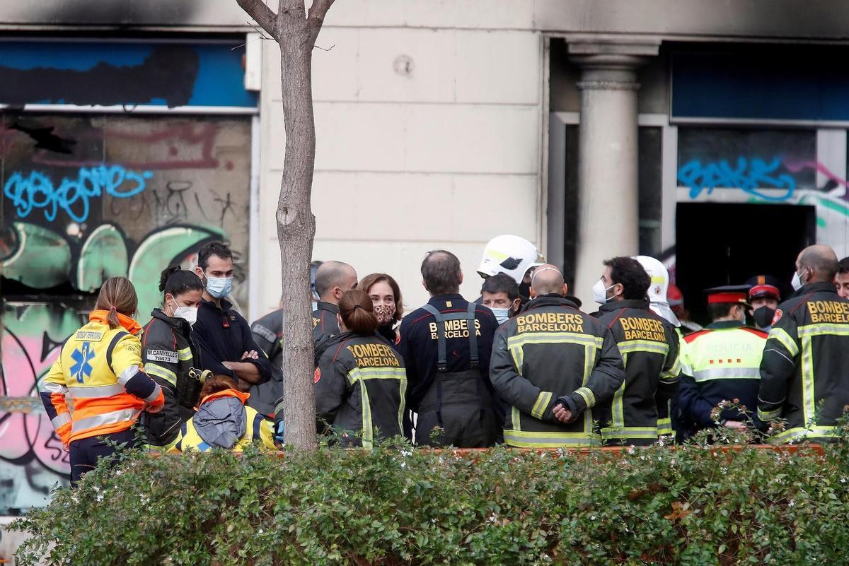 GRAFCAT239. BARCELONA, 30/11/2021.- La alcaldesa de Barcelona, Ada Colau, atiende a las explicaciones de los bomberos desplazados al lugar donde cuatro personas han muerto, dos de ellas dos menores de corta edad, al incendiarse esta mañana el local en el que vivían en la plaza Tetuán de Barcelona. EFE/Marta Perez