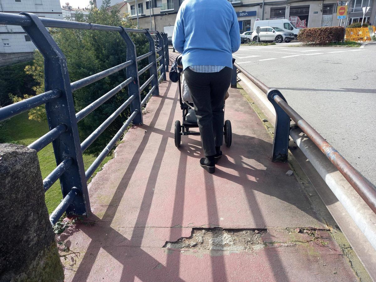 Uno de los numerosos baches en la acera del puente en la rotonda de A Barca.