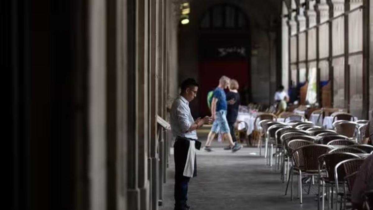 Un camarero esperando clientes para la terraza de un bar