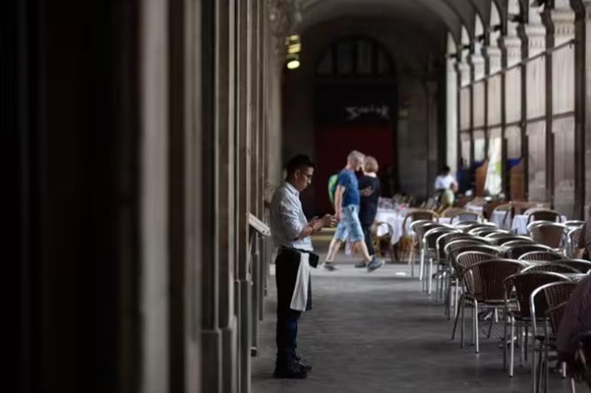 Un camarero esperando clientes para la terraza de un bar