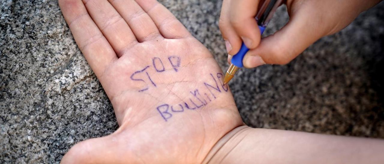 Un niño pinta en su mano ’stop bullying’.