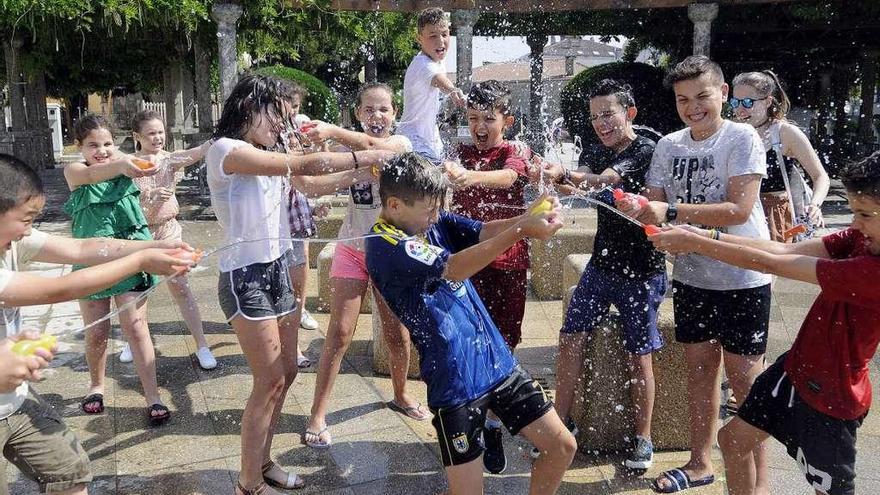 Un grupo de niños se refresca con agua en la nueva fuente del parque de Silleda. // Bernabé/Javier Lalín
