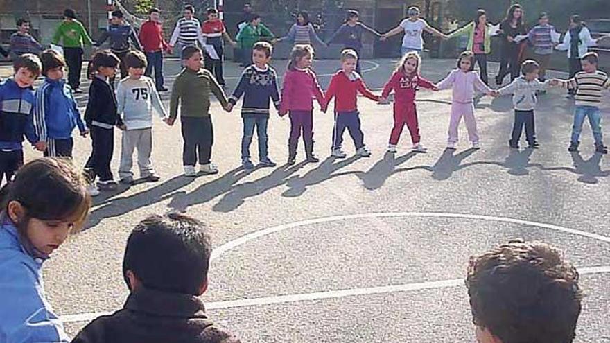 Niños de un colegio de Infantil y Primaria en la comarca celebran el Día de la Paz en el patio del centro.  // Carmen G.