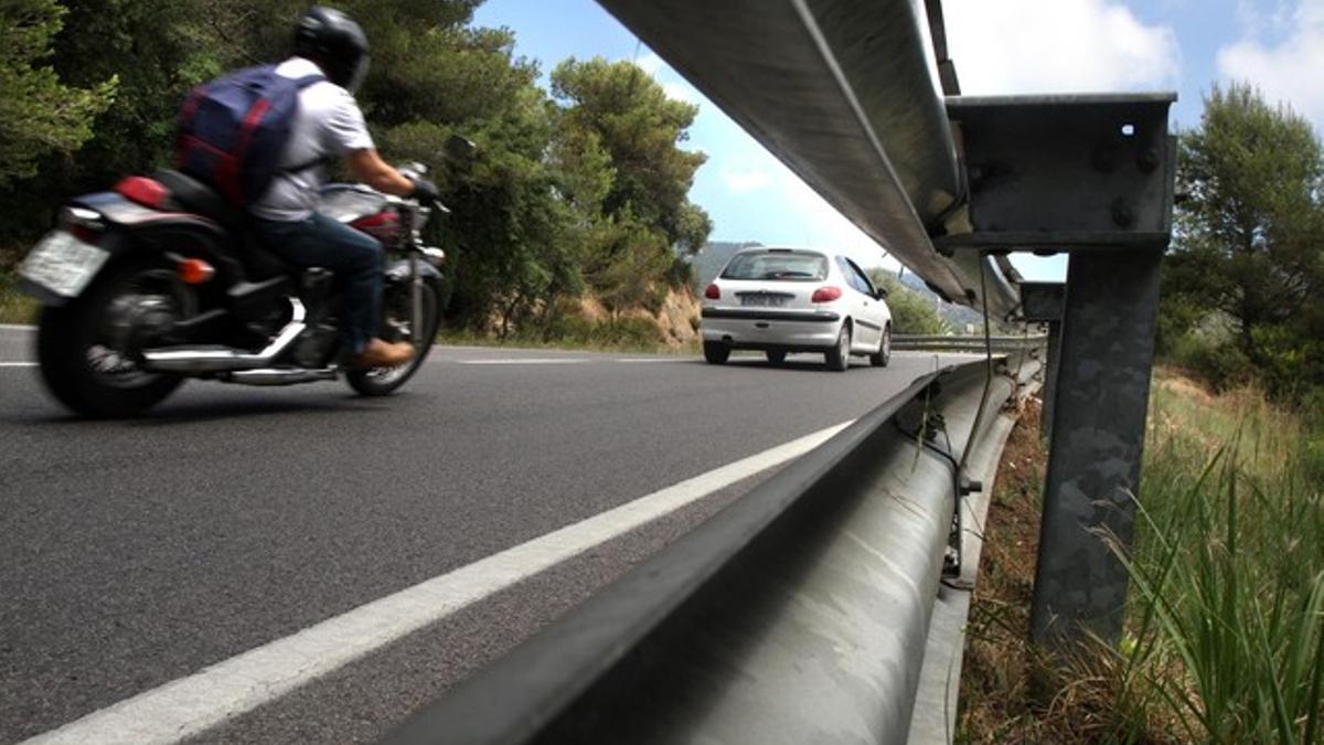 Una moto circula por la sinuosa carretera entre Tossa de Mar y Lloret.