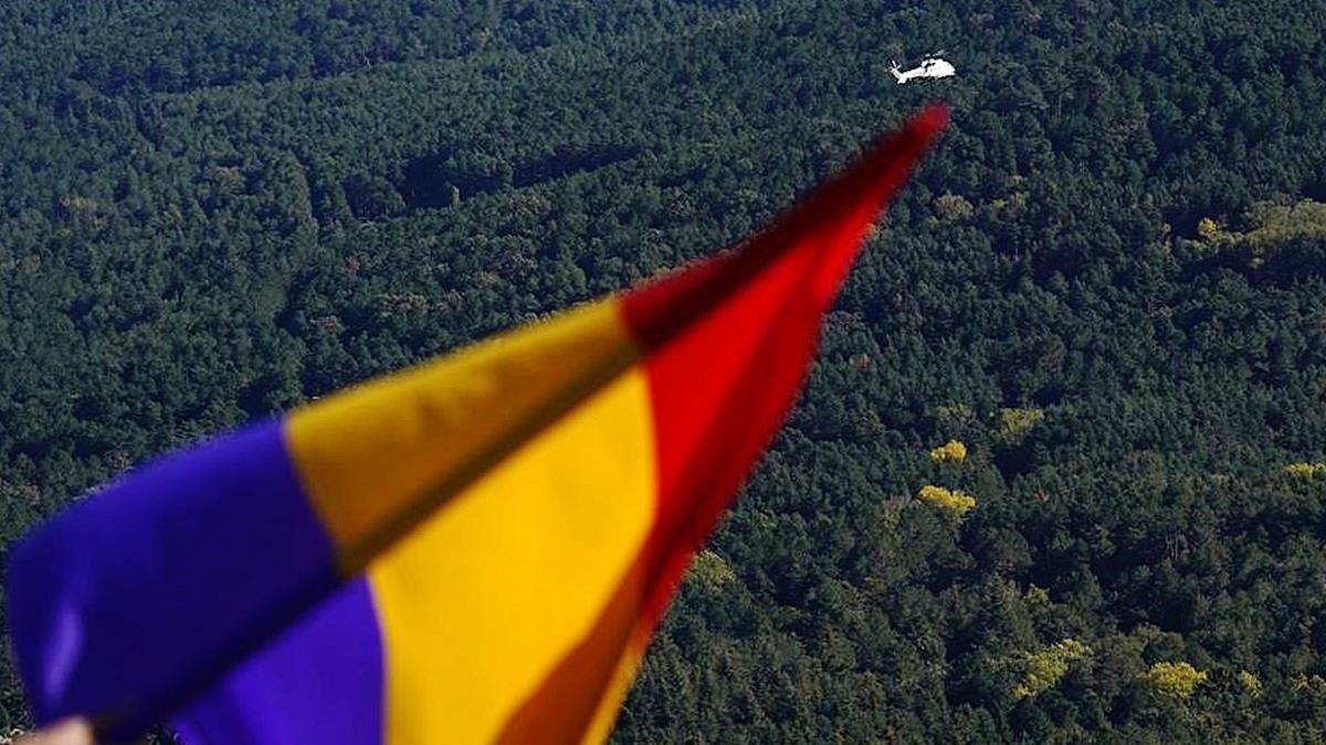 Una bandera republicana española y, al fondo, el helicóptero con los restos de Franco.