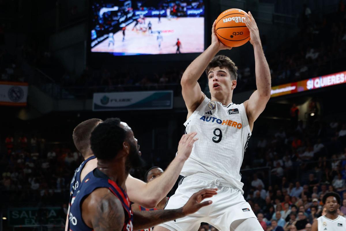 MADRID, 03/06/2025.- El alero del Real Madrid Hugo González (d) lanza ante dos rivales del Baskonia durante el primer partido del playoff de cuartos de final de la Liga Endesa de baloncesto que se disputa este martes en el Movistar Arena de Madrid. EFE/ Juanjo Martin