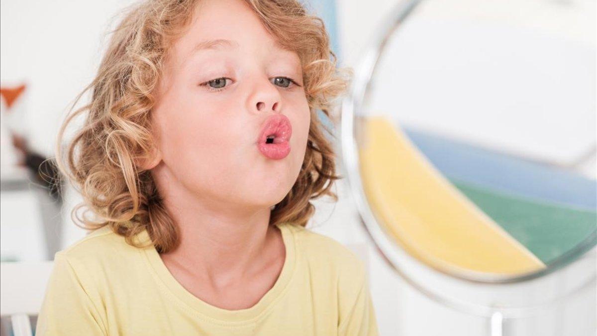 Un niño habla solo frente al espejo