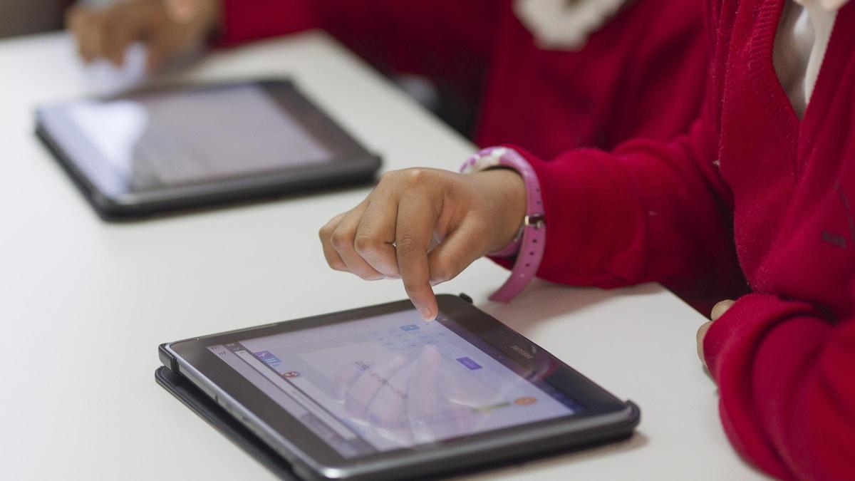 Escolares manejando sus tablets en un colegio.