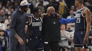 Dallas Mavericks Anthony Davis, left, and a staff member, right, assist Kyrie Irving (11) off the court after he suffered an unknown injury in the first half of an NBA basketball game against the Sacramento Kings in Dallas, Monday, March 3, 2025. (AP Photo/Tony Gutierrez)