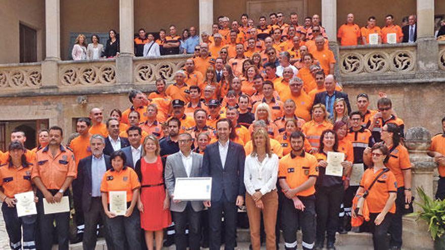 Los homenajeados, ayer, con el president, la delegada del Gobierno y el director de Emergencias.