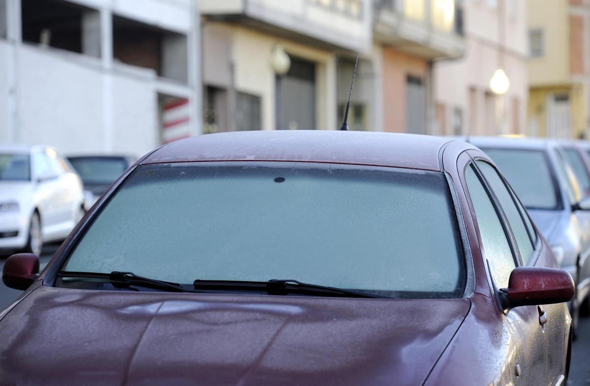 Varios coches con hielo en el parabrisas.