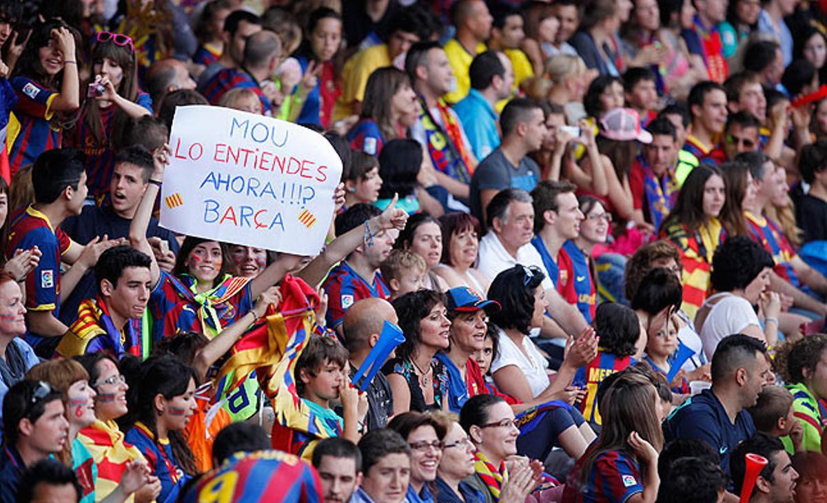 Una aficionada mostra un cartell aquest diumenge dirigit a l’entrenador del Reial Madrid en les celebracions del Camp Nou pel trofeu de Champions que va aconseguir el Barça dissabte.