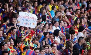Una aficionada mostra un cartell aquest diumenge dirigit a l’entrenador del Reial Madrid en les celebracions del Camp Nou pel trofeu de Champions que va aconseguir el Barça dissabte.