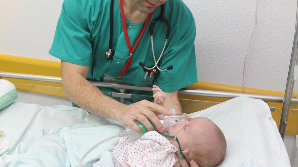 Un sanitario coloca un respirador a un bebé con problemas para hacerlo.
