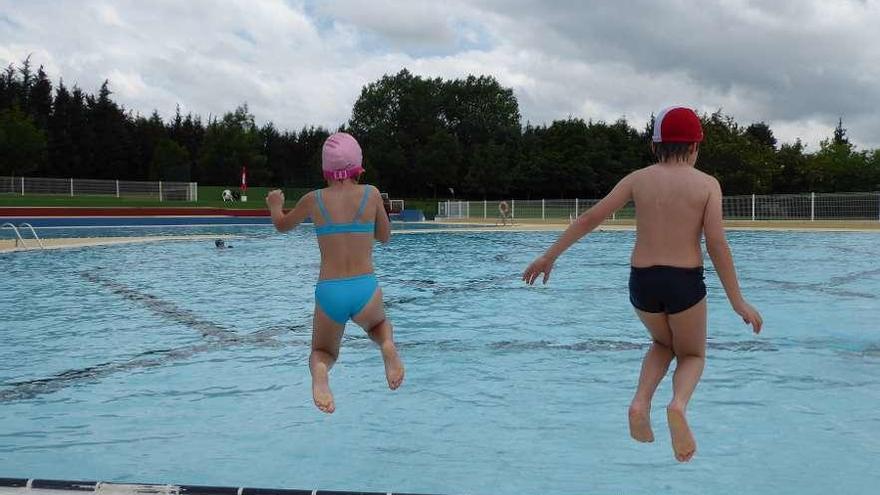 Dos menores saltan al agua en la piscina de La Morgal.