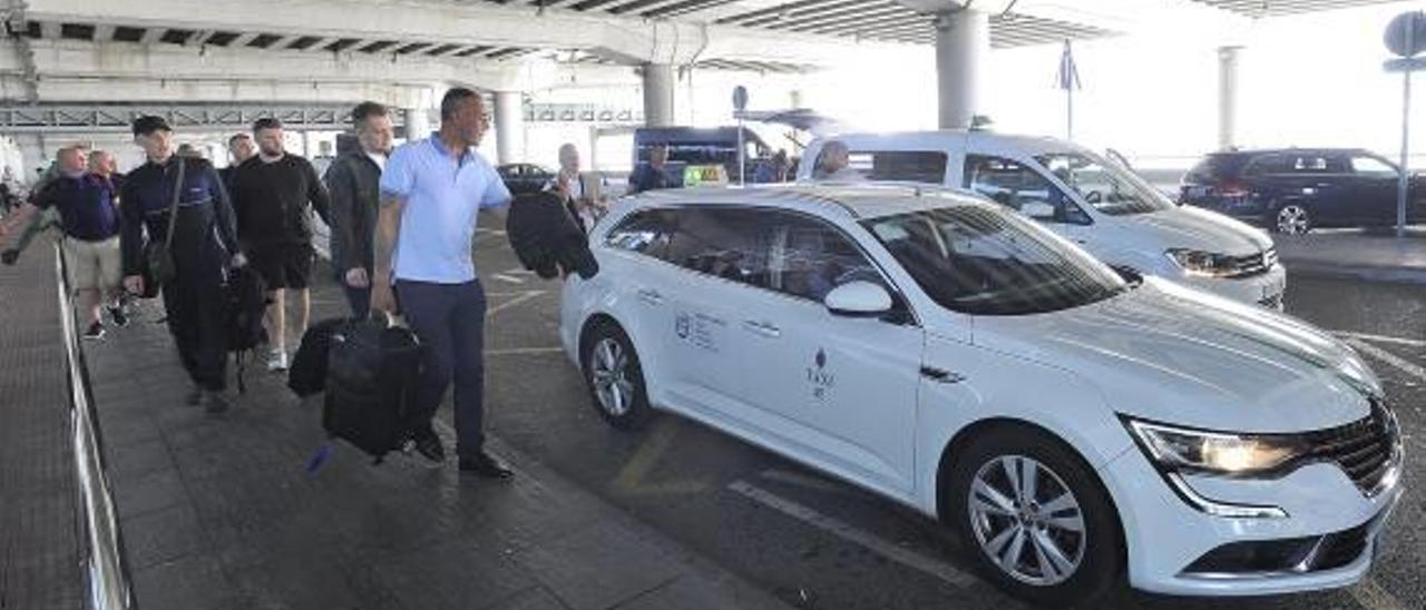 Pasajeros a la espera de coger un taxi en el aeropuerto, esta semana.