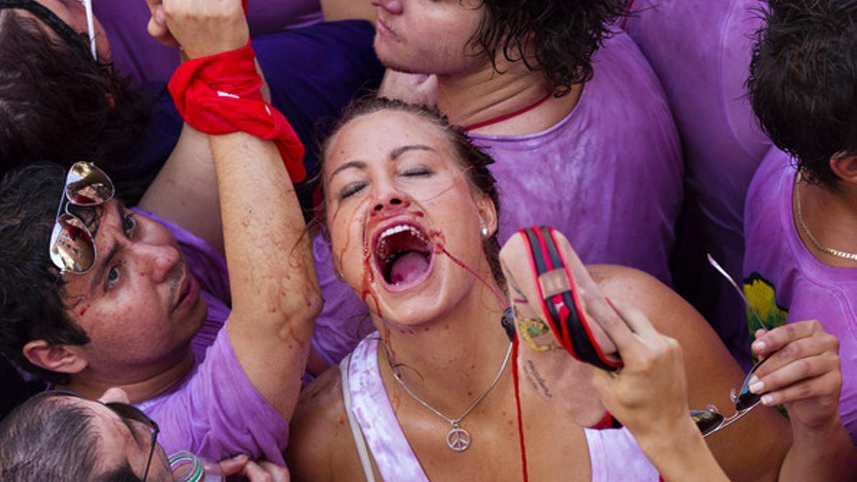 Varias personas riegan con vino el inicio de las fiestas de Pamplona.