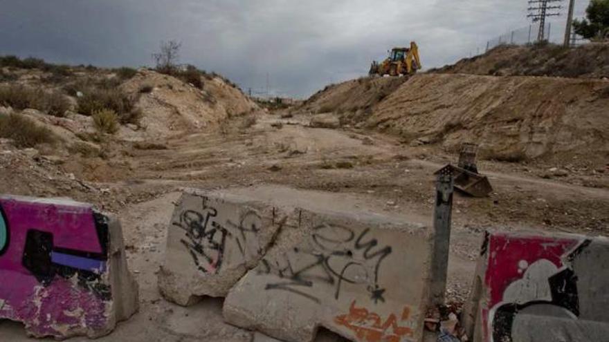 Una excavadora trabaja en los terrenos que separan el final de la Vía Parque y la vieja carretera.