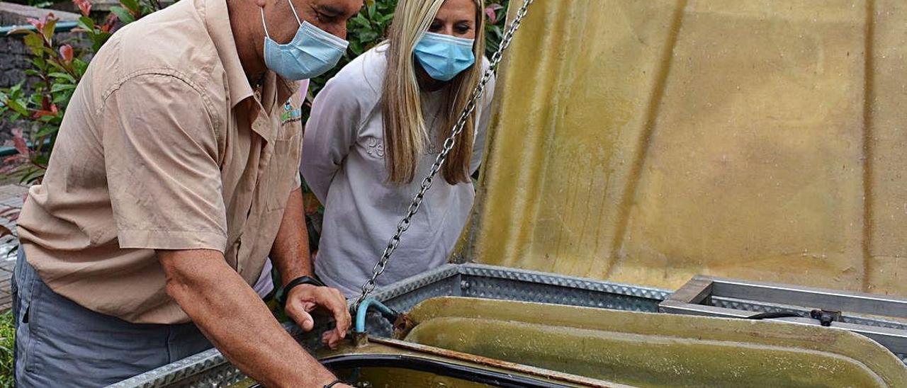 Nicolás Ferrer extrae los alevines de la cuba ante la atenta mirada de la edil de Noreña Eva María Nunes. A la derecha, la suelta en el río .