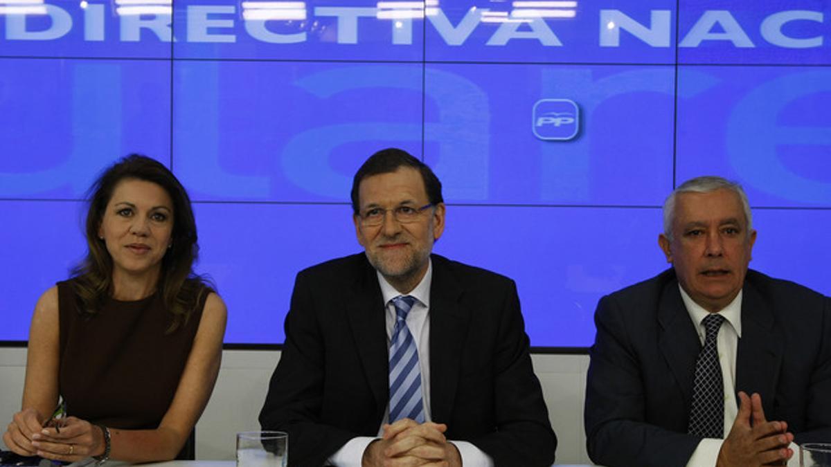 Mariano Rajoy, flanqueado por Dolores de Cospedal y Javier Arenas, en la junta directiva nacional del PP, este miércoles en Madrid.