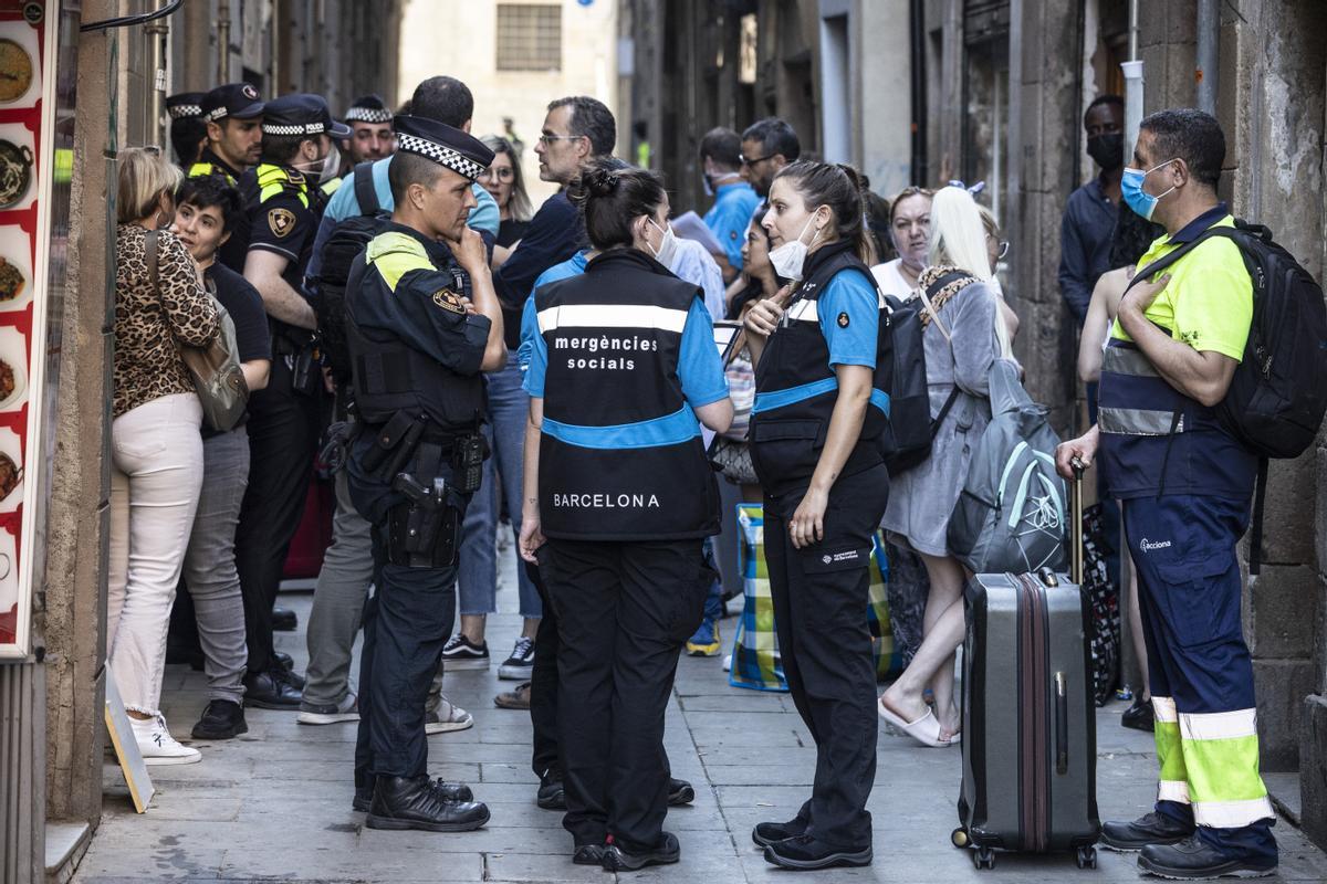 Los técnicos del CUESB asisten en un desalojo de un edificio de la calle Robadors, en el barrio del Raval, donde los vecinos ya les esperan con las maletas.