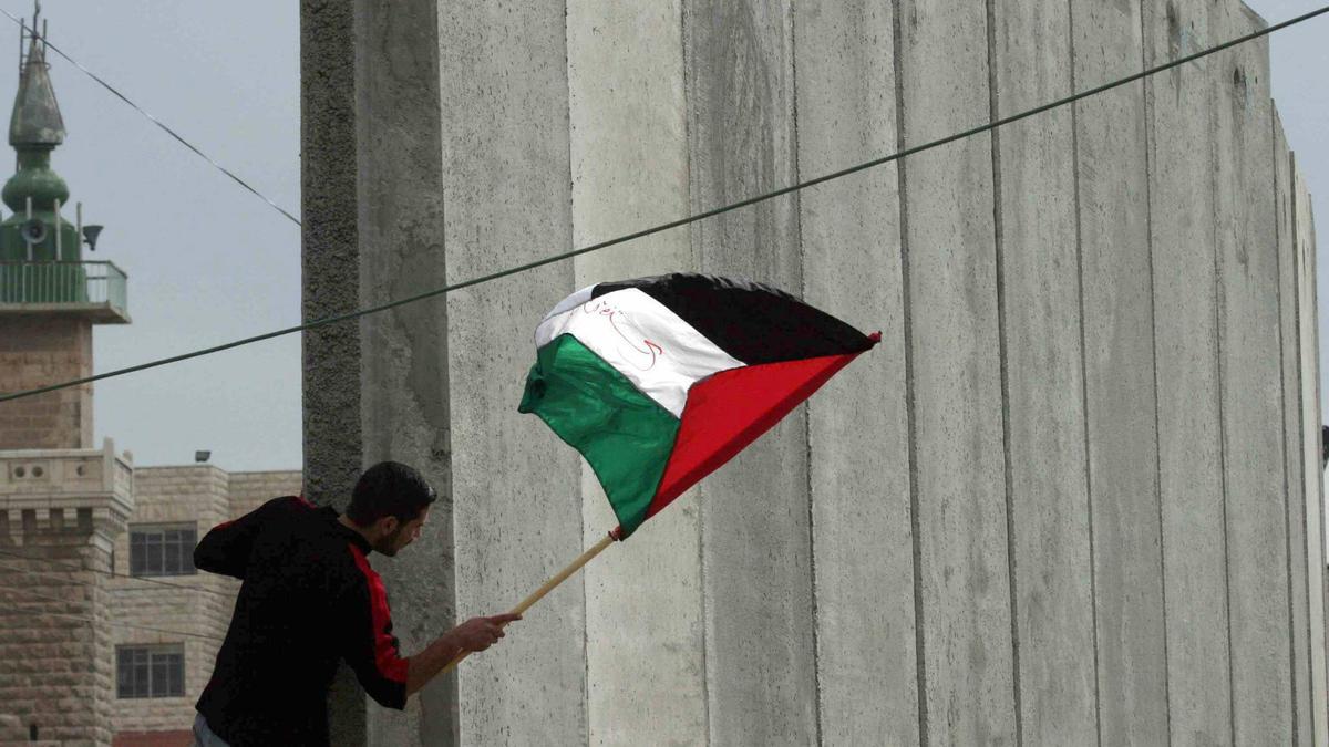 09/02/2004, Jerusalén.- Un palestino agita una bandera en una protesta contra la ocupación israelí