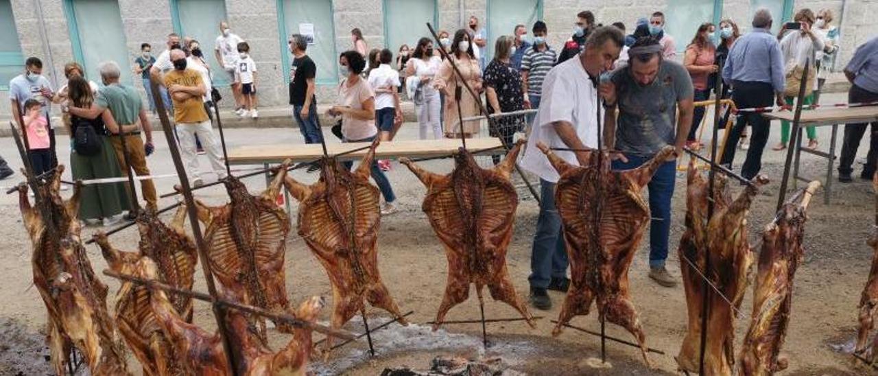 Un cocinero muestra al actor Luis Zahera el proceso de asado.   | // SANTOS ÁLVAREZ