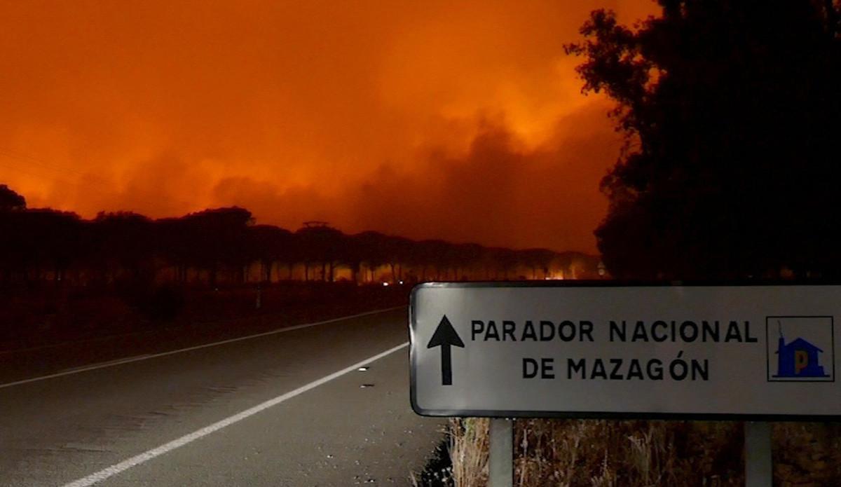 GRA005. MOGUER (HUELVA), 25/06/2017.- Imagen de EFE Televisión del incendio declarado anoche en el paraje La Peñuela de Moguer (Huelva) que ha entrado en el Espacio Natural de Doñana, según ha confirmado el consejero de Medio Ambiente y Ordenación del Territorio, José Fiscal. Un total de 57 efectivos de la Unidad Militar de Emergencias y once medios aéreos se han incorporado al operativo de extinción del incendio forestal declarado a las 21:30 horas ayer en el paraje La Peñuela, de Moguer (Huelva), que continúa activo, y que ha obligado al desalojo de más de 300 personas. La dirección del Plan Infoca ha autorizado el regreso de las personas que fueron desalojadas esta madrugada del Hotel Solvasa y de las viviendas de la zona conocida como Bonares en Mazagón (Huelva) por el incendio. Por su parte, aún no han podido hacerlo las personas que se alojaban en el cámping Cuesta de la Barca, el poblado forestal, el Parador de Mazagón, el cámping Doñana y del Instituto Nacional de Técnica Aeroe