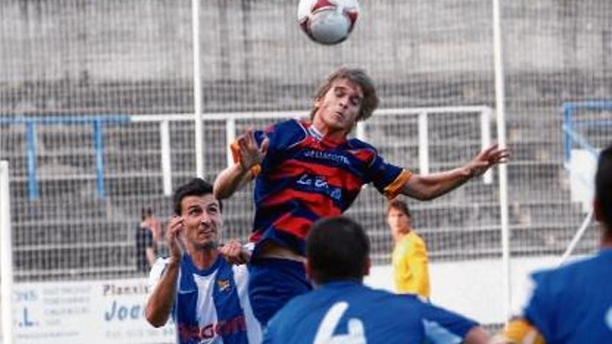 El davanter del llagostera, Jordi Aumatell, remata de cap envoltat de jugadors de la Unió.